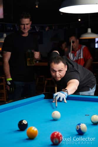 Commercial photo of a patron taking a shot on the billiards table.