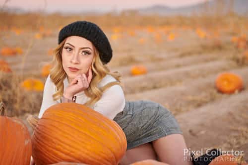 Laying down and leaning on a pile of pumpkins during her glamour session.