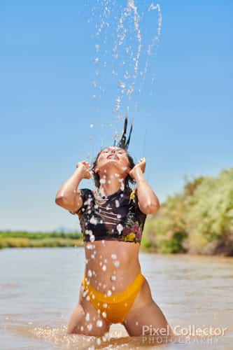 Wetting her hair in the river.