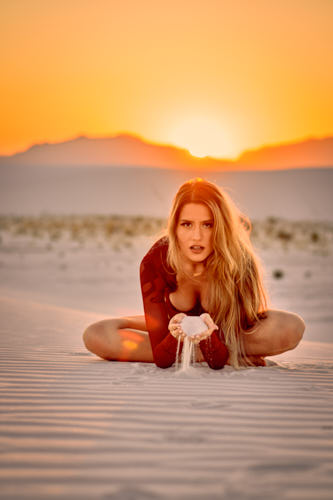 Young lady playing with the sand during a glamour photography session with Pixel Collector Photography.