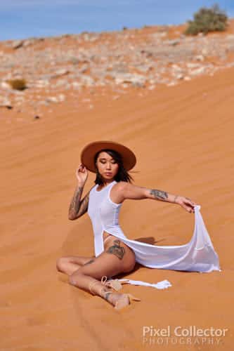 glamour photograph of woman sitting in the desert sand