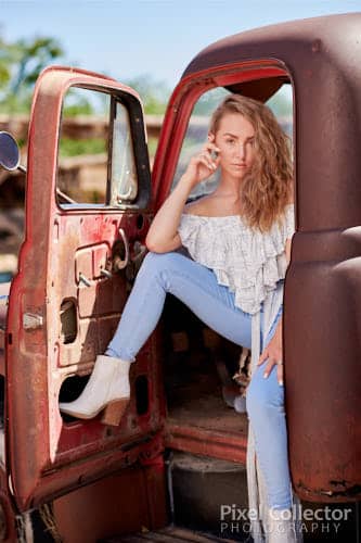 Sitting in the doorway of her old truck.