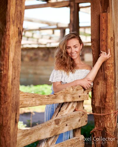 Hannah leaning against a post in a barn.