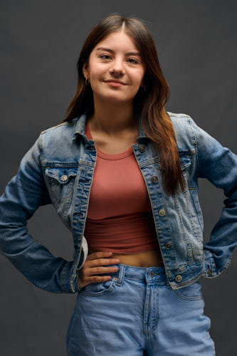 Portrait of young woman with a lovely smile standing with her hands on her hips.